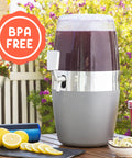 Contenitore bevande Avilia BPA free in ambiente esterno giardino con cola scura, limoni freschi, perfetto per feste all'aperto